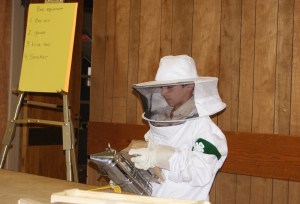 Caleb Schlichtung demonstrating his beekeeping outfit.
