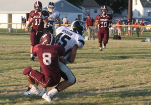 Bobby Simpson and Marcus Hegy look on as Taylor Fuston tackles a Knight receiver.Photo Credit/Steven Hosch.
