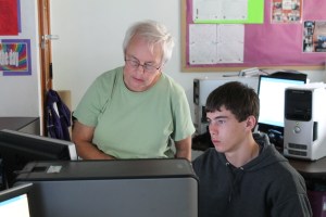 Linda Bisanz, Nebraska SHIIP Volunteer assists Mark Heaney in the computer classroom as he learns how to compare Medicare Prescription Drug Plans with the on-line Medicare Plan finder program. Call UNL Extension at 402-374-2929 to make an appointment to get help comparing your Medicare plans so you don’t pay too much next year.  Photo Courtesy Mary Loftis.
