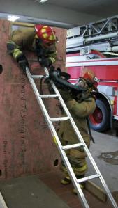 Training how to access a basement through a tiny window wearing all your bunker gear. Photo Courtesy of Donnie Dodge.