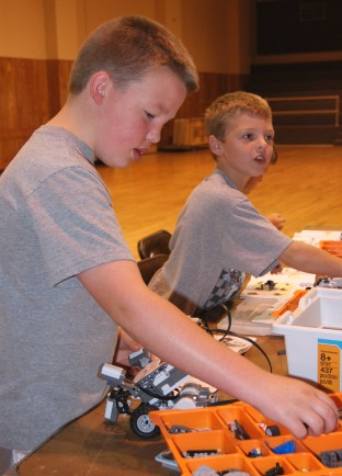 Trevor Weitzenkamp of Oakland and Isaac Ruwe of Tekamah sort through hundreds of little Lego pieces to correctly assemble their NXT Mindstorm robot at the UNL Extension sponsored robotics camp held last week in Tekamah. Photo Credit/Mary Loftis, Extension Assistant.