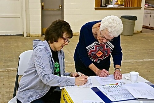 Jane Sunderman, right, is assisting Sara Cameron with some paperwork prior to Sara voting in Lyons, NE. Photo Credit/Denise Gilliland, Editor and Chief, Kat Country Hub.