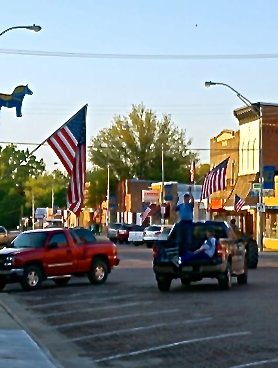 Bill Hultquist, a veteran and American Legion member, holds up the American flag while out putting the flags on Oakland's Main Street. Photo Credit/Denise Gilliland, Editor and Chief, Kat Country Hub.