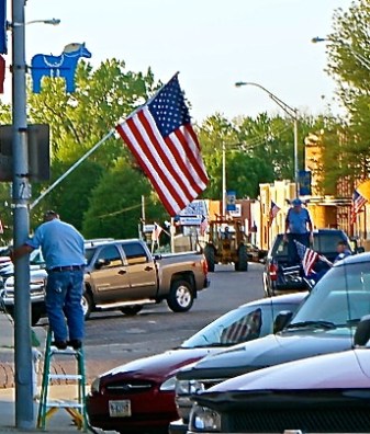 The American Legion placed flags on Oakland's Main Street. Bill Hultquist hung this one up. Photo Credit/Denise Gilliland, Editor and Chief, Kat Country Hub.
