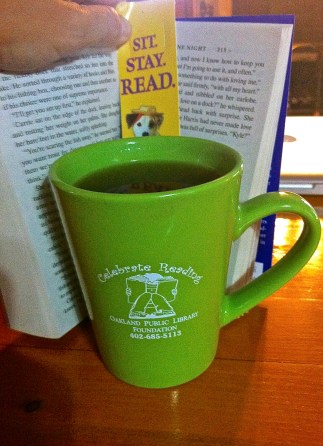 Starting my day with a book and a cup of coffee in my new cup purchased at Oakland Public Library. Purchase yours today and enjoy coffee for half price for a year at the library's new coffee bar! Photo Credit/Denise Gilliland, Editor and Chief, Kat Country Hub.