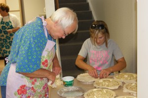 4-H Pie Chair, Linda Bisanz gets help from 4-H Mom, Kylie Hansen as they work on apples during Pie Day I in Tekamah last week.  Photo Credit/Mary Loftis.