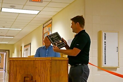 Architect for the project, and graduate of Oakland-Craig School, Curtis Johnson, commemorates the event by presenting a plaque to the school. Photo Credit/Denise Gilliland, Editor and Chief, Kat Country Hub. 