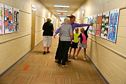 Troy Denton is pointing out some artwork on the walls to others at O-C's new elementary addition. Photo Credit/Denise Gilliland, Editor and Chief, Kat Country Hub.