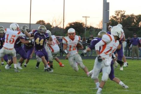 Nick Arlt, #12, takes off running as #15 Zach Ahrens and #16 Bob Gatewood block for him. Photo Credit/Cheri Droescher.