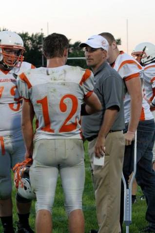 Nick Arlt, #12, and Black Uhing, #73, talk things over with assistant coach Nick Arlt. Photo Credit/Cheri Droescher.
