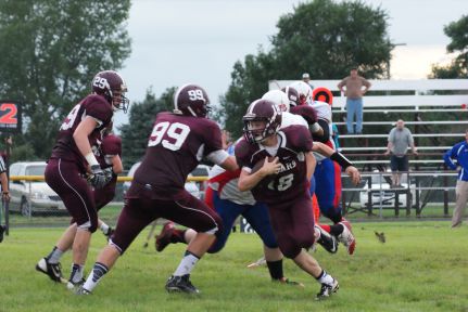 Charles Webb, 29 and Cole Christoffersen, 99, block for ball carrier Montana Riecken. Photo Credit/Pat Sharp LDNE.