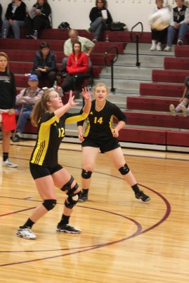 Brianne Haskell readies herself for the ball as Abby Peterson is ready to help. Photo Credit/Rhonda Hansen.