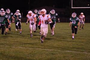 Bryce Uhing runs away from a pack of Wisner-Pilger players, with Tommy Nelson not far behind. Photo Credit/Cheri Droescher. 
