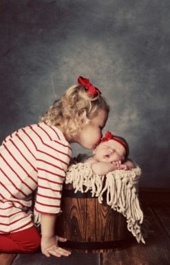 Paisley Peterson kissing her newborn sister Hadley. Photo Credit/Lisa Johnson. 