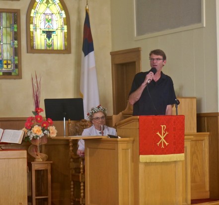Karl Lundquist, Oakland Swedish Festival Chairman, opened the Swedish Festival at the Methodist Church Friday Evening. Seated behind him is Patty Miller. Photo Credit/Denise Gilliland, Editor and Chief, Kat Country Hub. 
