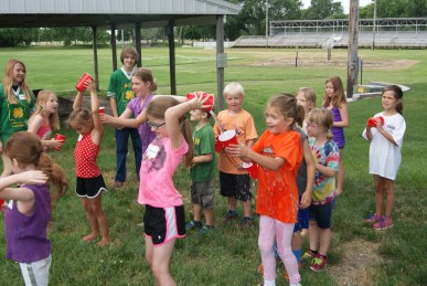 The water relay was a hit with the 4-H Clover Kid Campers as they took turns pouring a cup of water over their heads for their team member to catch behind them. Photo Credit/Mary Loftis. 