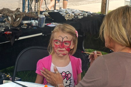 Connie Fager's daughter, Pam, did face painting at the fair, along with selling jewelry and other items. This little gal wanted a red sparkly butterfly. Photo credit/Denise Gilliland, Editor and Chief, Kat Country Hub.