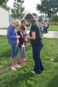 Nebraska Extension Associate, Mary Loftis helps Oakland-Craig 5th graders understand how to use a compass at the GPS workshop in West Point.