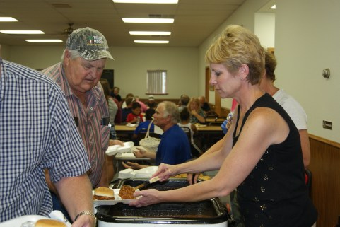 Michelle Smith serves Roger Johnson at the Craig Community fundraiser for the Steve and  Terry Nesemeier family of Craig who lost their home and belongings to a fire earlier this month. Photo Credit/Mary Loftis. 