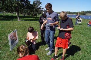 Lyons-Decatur students along with 6th graders from across the county took part in the 6th Grade Conservation Day at Summit Lake last week. Caleb Schlichting, Kaden Frahm, Trevor Cole and Tretyon Frahm roll the dice and record where they as a water molecule will go next from the Cloud in the Water Cycle during one of the Conservation Day activities. – photo by Mary Loftis  